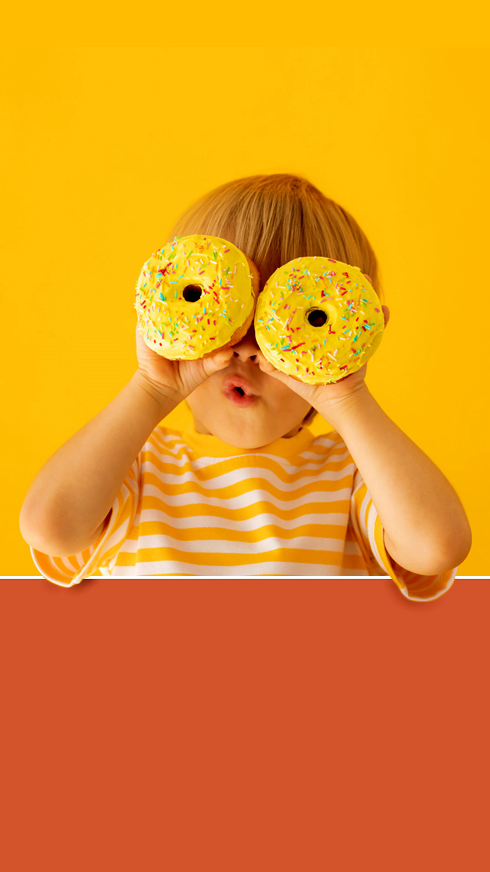 A child holding two yellow donuts in front of their eyes like binoculars